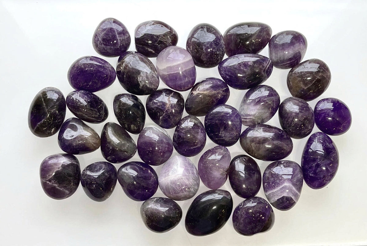 Group of purple amethyst tumbled gemstones On white background